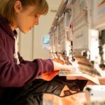 person embroidering merch